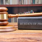 gavel resting on book entitled "burden of proof"